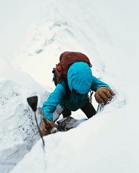 Mountaineer using an ice axe to climb Forcan Ridge in Glen Shiel, Scotland