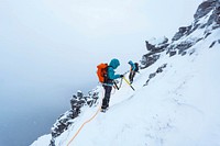 Mountaineers climbing a snowy Liathach Ridge in Scotland