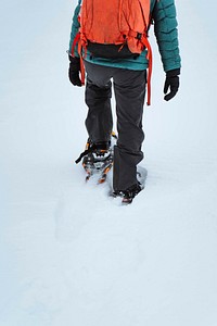 Hiker wearing snowshoes on a trail in the snow