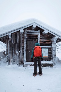 Woman standing in front of a snowy hut