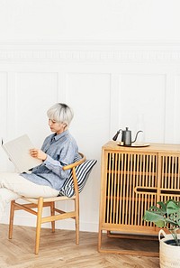 Asian woman siting on a chair reading a book