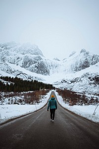 Young woman hiking up the road in Norway