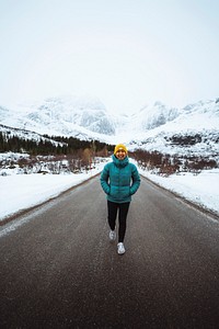 Young woman hiking up the road in Norway