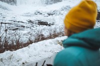 Woman flying a drone in Lofoten, Norway