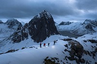 Hikers walking up Segla mountain during the blue hour