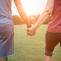 Close up of a couple holding hands at a park