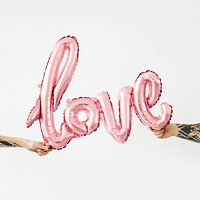 Hands holding a glossy pink love balloon