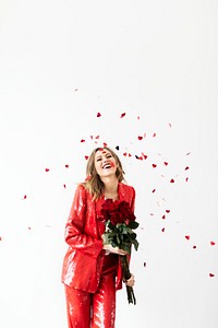 Happy woman in a red pantsuit with a bouquet of roses 