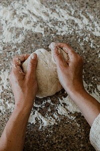 Woman kneading sourdough in her kitchen during quarantine