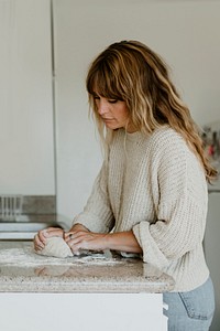 Woman kneading sourdough in her kitchen during quarantine