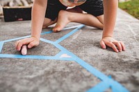 Education photo of kid holding a chalk sitting on the ground