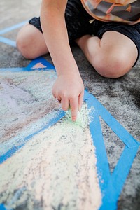 Kid painting concrete ground with a chalk education photography