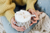 Woman at home drinking hot chocolate with whipped cream 