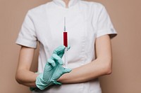 Nurse with a syringe in her gloved hand