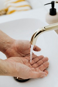 Man washing his hands under a running tap 
