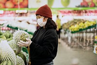 Woman with a medical mask buying fresh food during coronavirus pandemic