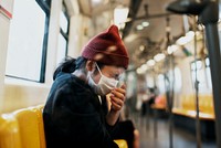 Sick woman in a mask sneezing in a train during coronavirus pandemic