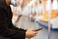 Woman using a phone on an empty train during coronavirus pandemic