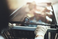 Woman wearing gloves to prevent coronavirus while using a shopping cart