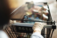 Woman wearing gloves to prevent coronavirus while using a shopping cart