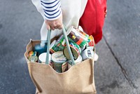 Woman walking with a bag of canned foods during coronavirus pandemic. BANGKOK, THAILAND, 24 March, 2020