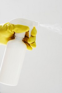 Rubber gloved hand holding a white spray bottle