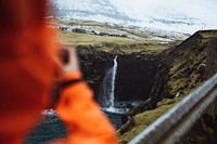 Photographer at M&uacute;lafossur waterfall in the Faroe Islands, part of the Kingdom of Denmark