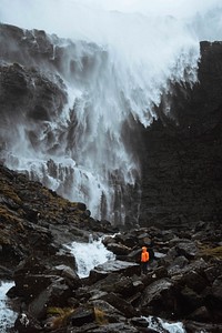Traveler at Foss&aacute; waterfall in the Faroe Islands