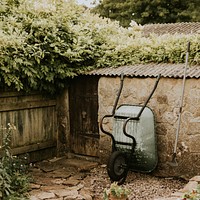 Wheelbarrow leaning on a garden shed