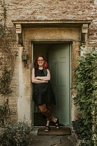 Woman gardener standing by open green door