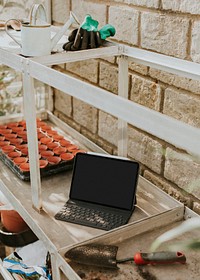 Black tablet on a gardening wooden table