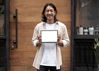 Japanese designer showing a digital tablet screen outside his sh