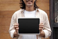 Digital tablet screen mockup psd in the hands of a casual Japanese designer