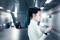 Girl texting on phone at the underground subway station