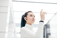 Asian girl touching virtual screen futuristic technology