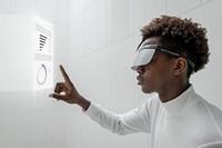 Man wearing smart glasses touching a holographic screen