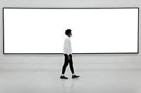 Man walking in front of a large billboard