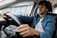 Man holding on tight to the steering wheel of a smart car