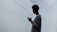 Silhouette of a man using a smartphone