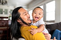  Asian American father hugging his son