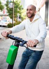 Man with hoodie rining an electric scooter