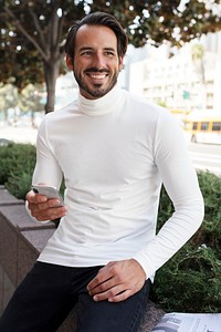 Businessman in turtleneck sitting and smiling in the city