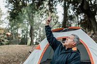 Elderly man searching for internet connection in the forest 