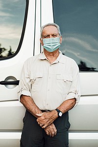 Senior man standing by the camper van in the new normal