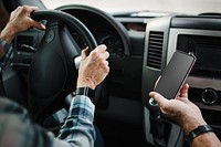 Grandpa showing his smartphone to grandma while driving