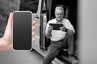 Smartphone black screen mockup psd with grandpa sitting on camper van