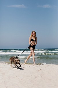 Woman walking her dog at the beach