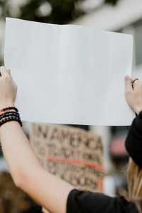 Woman holding a white placard with copy space at a black lives matter protest 