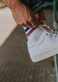 Model tying laces on white sneaker