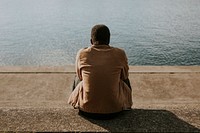 Black man sitting by the water